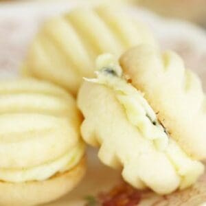 Three cream-filled sandwich cookies on a floral-patterned plate.