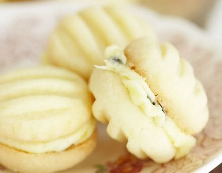 Three cream-filled sandwich cookies on a floral-patterned plate.