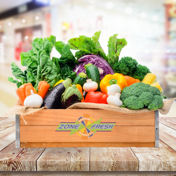 LARGE VEGETABLE BOX Wooden crate with mixed vegetables, labeled "Zone Fresh Gourmet Markets" in blurry indoor setting.