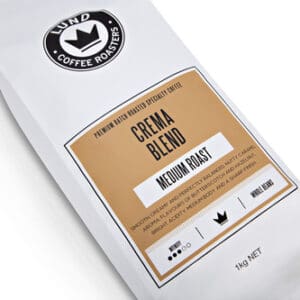 White bag labeled "Lund Coffee Roasters" with Crema Blend, Medium Roast, 1kg, flavor details.