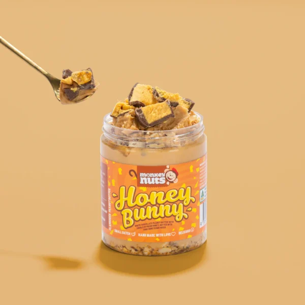 MONKEY NUTS HONEY BUNNY Peanut Butter Monkey Nuts Honey Bunny peanut butter jar topped with chocolate honeycomb on beige background.