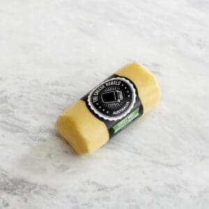 Butter, crispbread, and thyme on a wooden board; potted plants in the background.