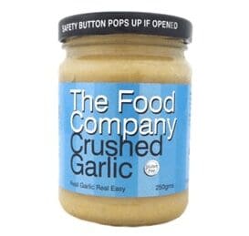 Jar of The Food Company Crushed Garlic, 250g, with black lid and blue label.