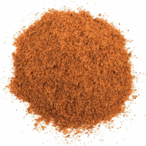 Pile of reddish-brown spice mix on a white background, coarse and granular texture.