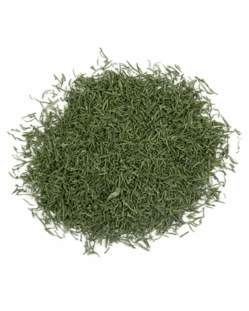 A pile of finely chopped dried dill leaves on a white background.