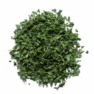 Pile of finely chopped green dried herbs on a white background.