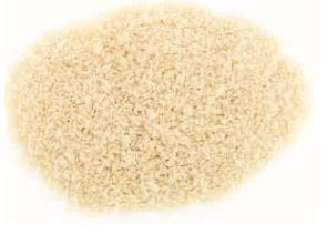 Pile of small, uniformly beige uncooked rice on a plain white background.