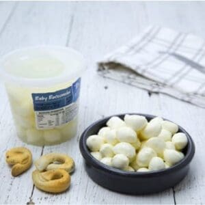 Bowl of cheese balls, plastic container labeled “Baby Bocconcini”, breadsticks, napkin.