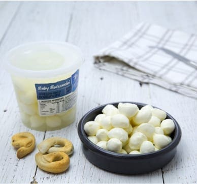 Bowl of cheese balls, plastic container labeled “Baby Bocconcini”, breadsticks, napkin.
