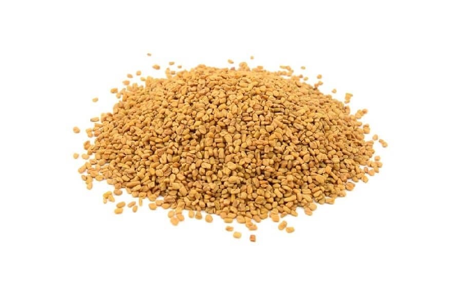 Pile of small, brownish-yellow seeds on a white background.