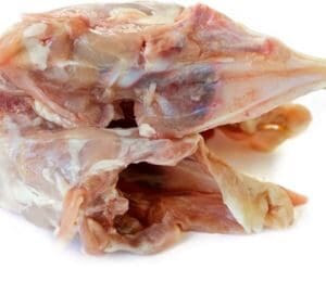 Pile of chicken carcasses with bones and tissue on a white background.