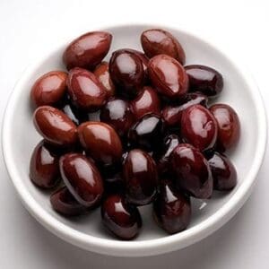 Bowl of dark reddish-brown glossy olives on a white background.