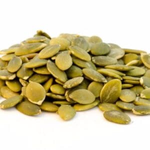 Close-up of green pumpkin seeds (pepitas) on a white background, flat and glossy.