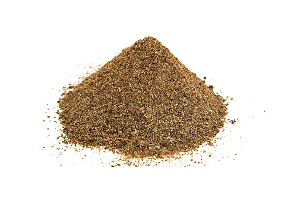 Ground black pepper in a conical pile on white background, coarse texture, dark with light specks.