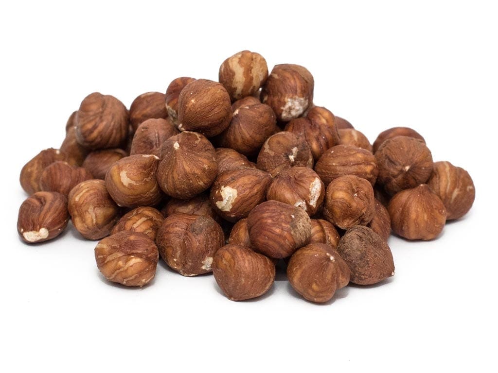 Pile of raw hazelnuts with brown shells on a white background.