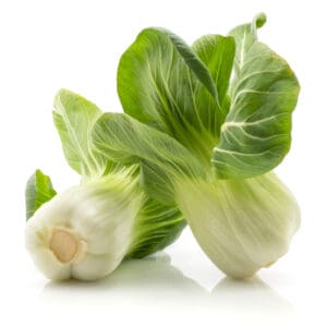 Two fresh bok choy with green leaves and white stalks on a white surface.