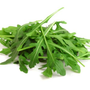 A pile of fresh arugula leaves with jagged edges on a plain white background.