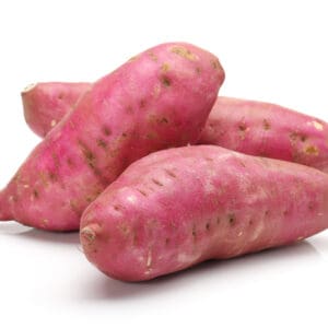 Wicker basket with large reddish-brown sweet potatoes on wooden surface.