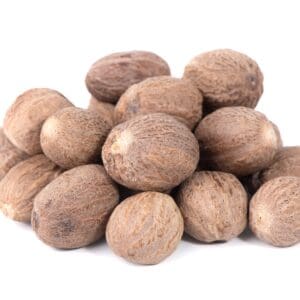 Whole nutmeg seeds with rough brown surface on a white background.