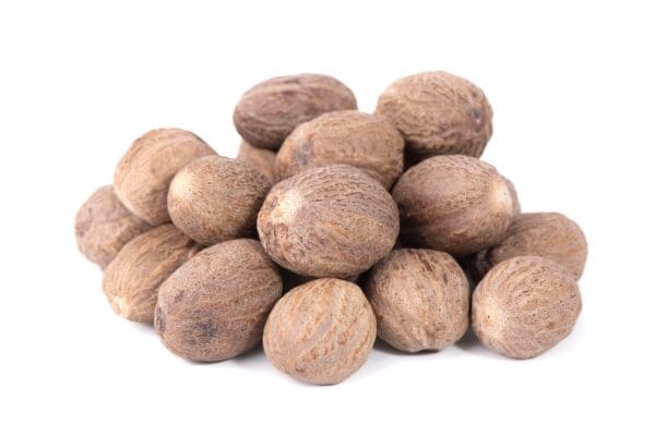 Whole nutmeg seeds with rough brown surface on a white background.