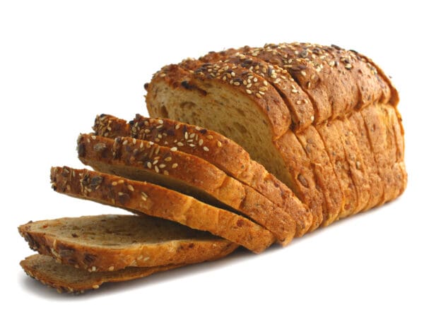 Sliced multigrain bread loaf with seed-topped crust on display.