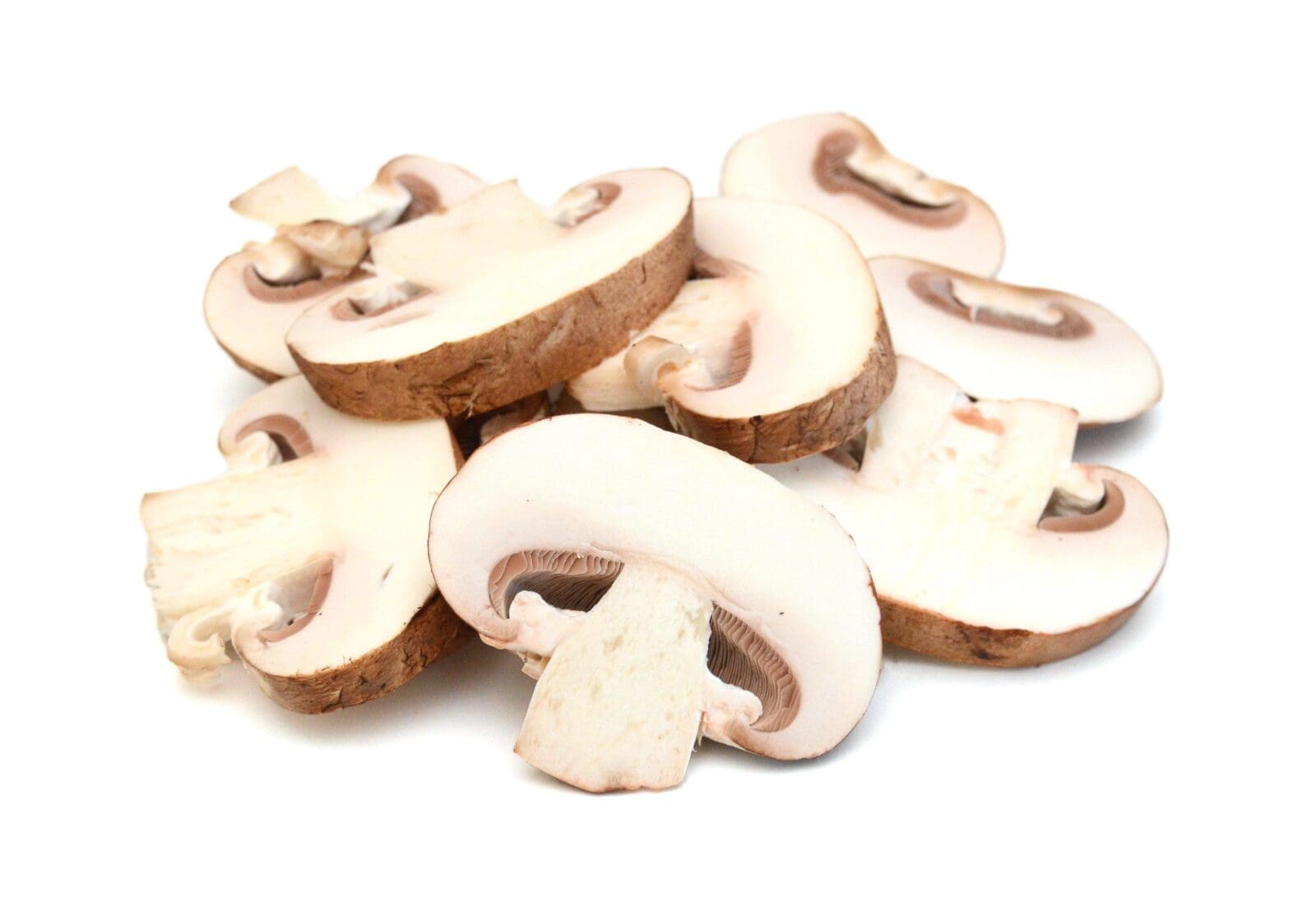 Sliced white mushrooms with brown caps showing smooth surfaces and gill structures.