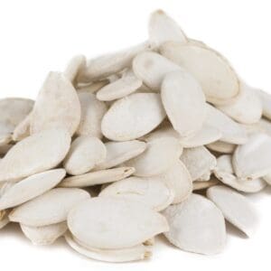Pile of white pumpkin seeds on white background, smooth, flat, and oval in shape.